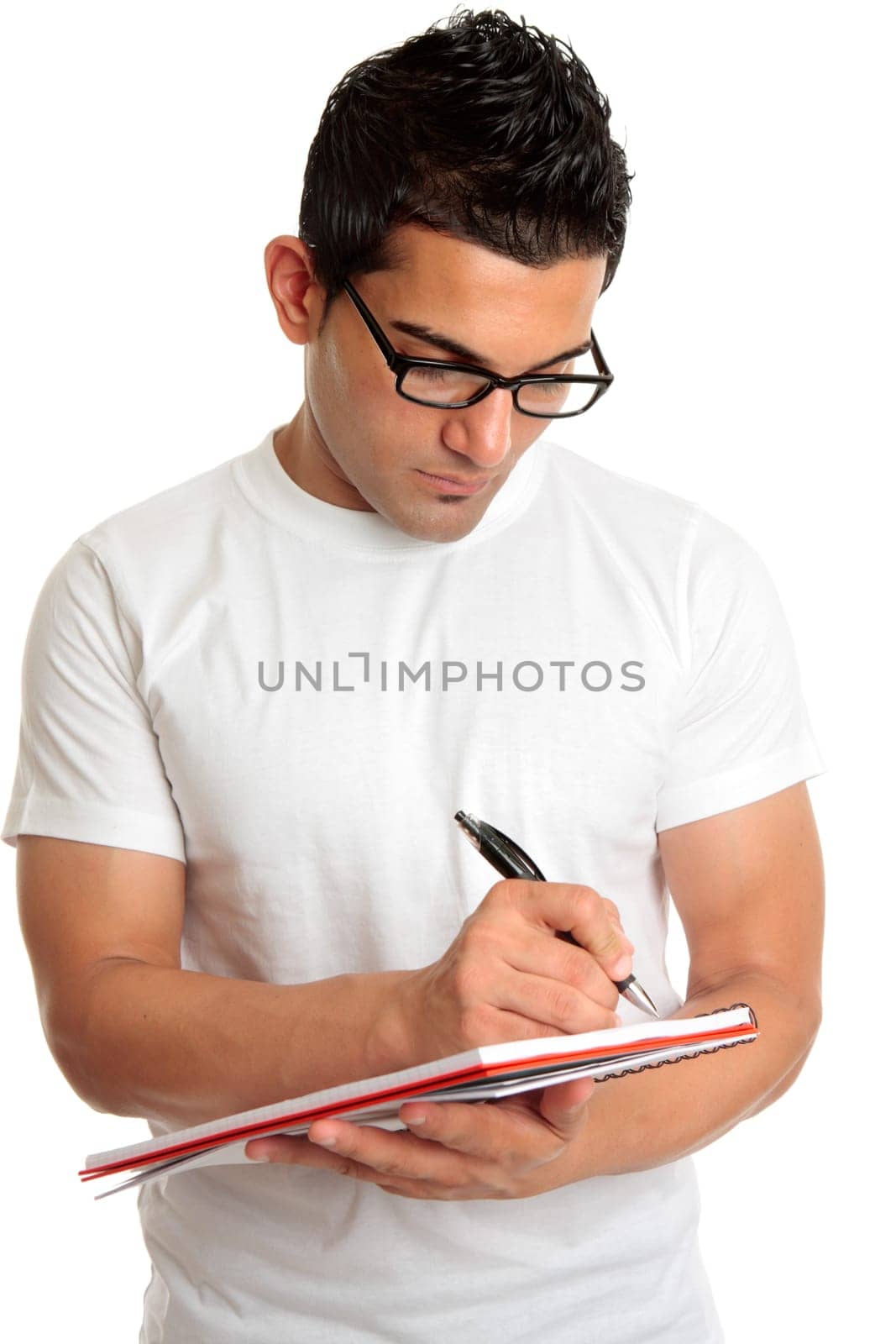 Student in glasses writes in book