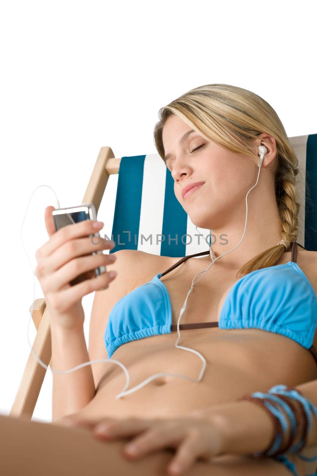 Beach - Young woman in bikini sitting on deck chair