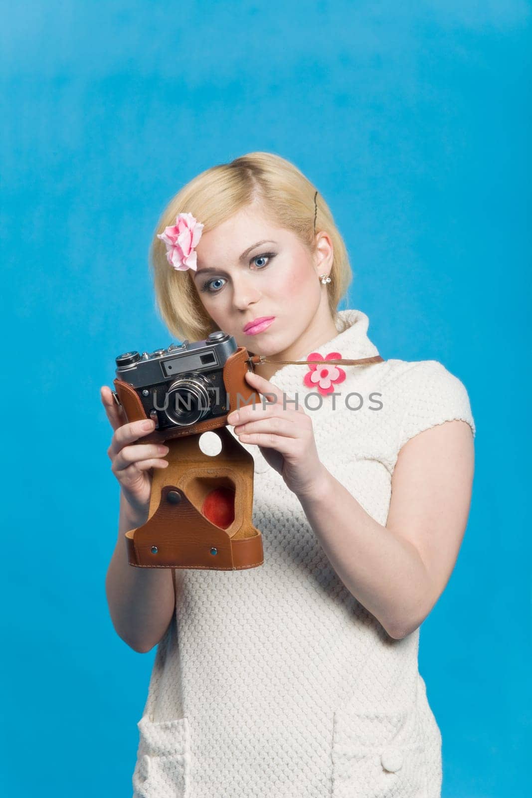 Blond girl look at retro camera