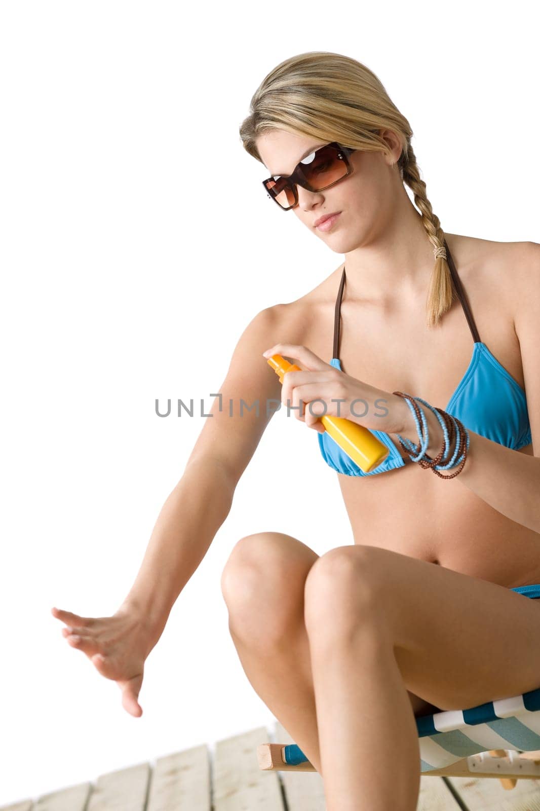 Beach - Young woman in bikini  apply suntan lotion