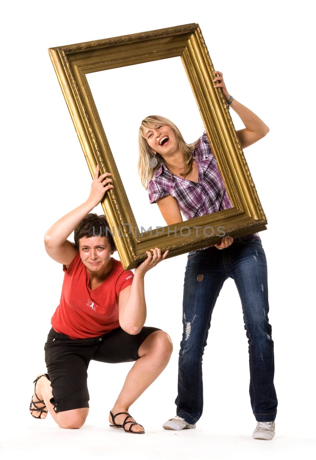 Young women posing with wooden frame
