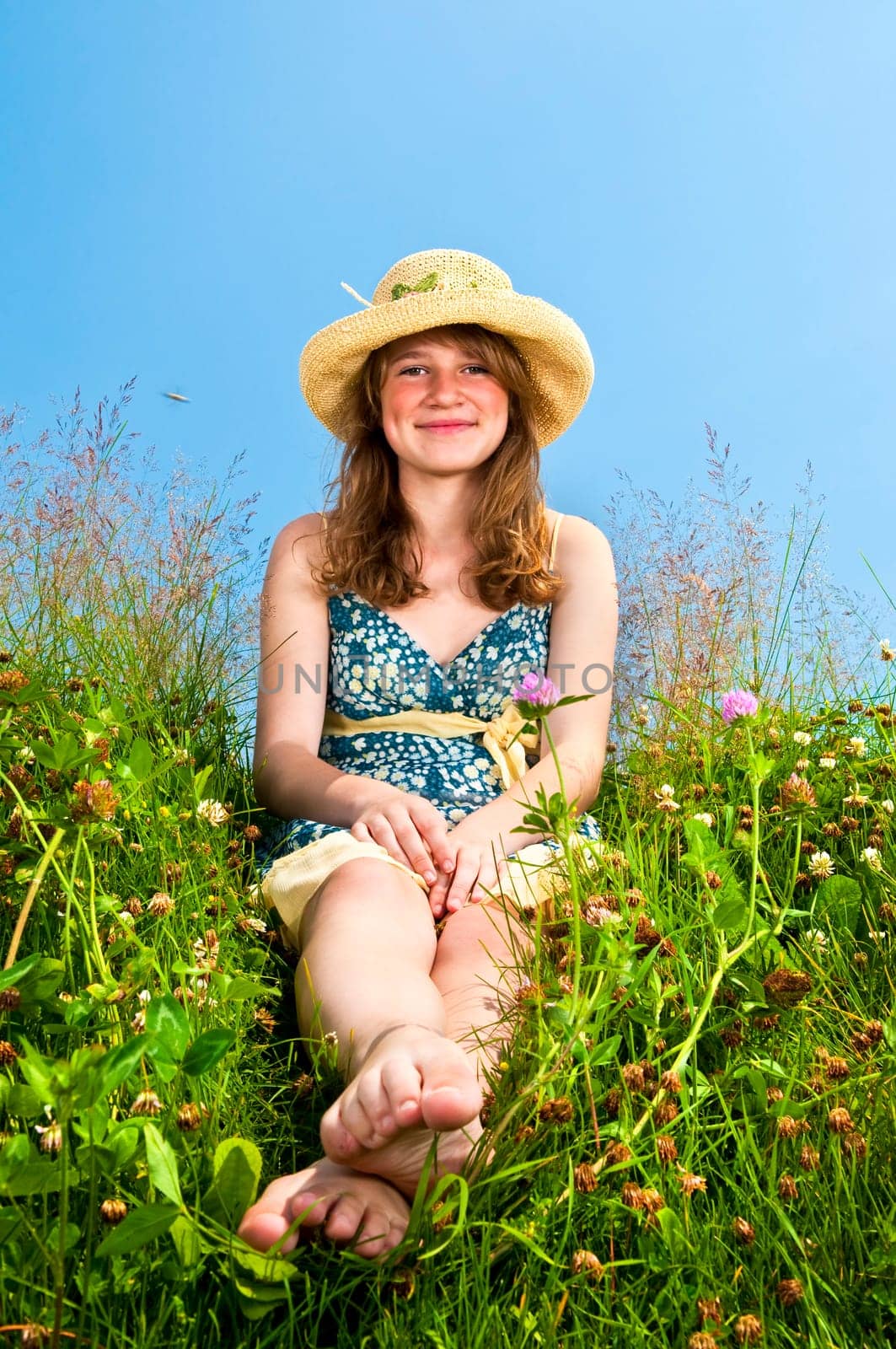 Young girl sitting in meadow