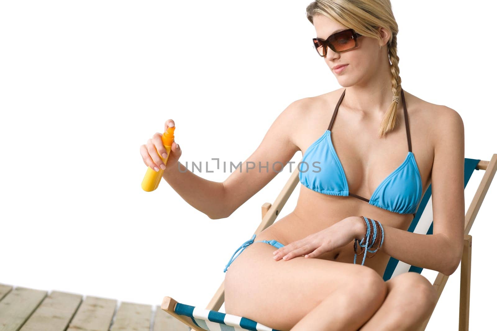 Beach - Young woman in bikini apply suntan lotion