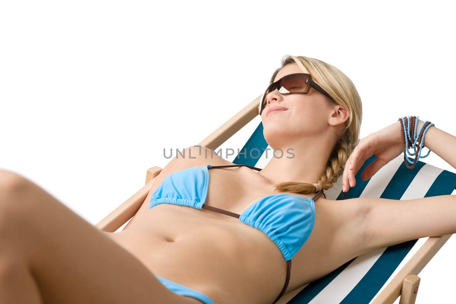 Beach - Young woman in bikini sitting on deck chair relaxing