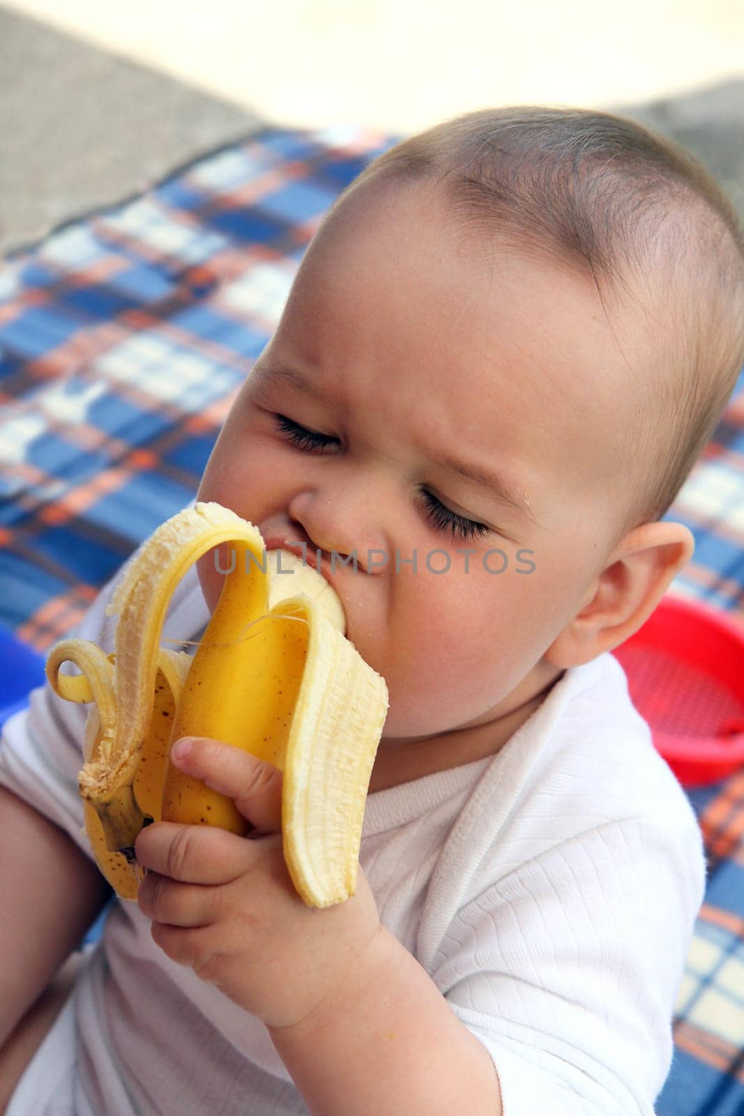 child eat yellow banana in outdoors