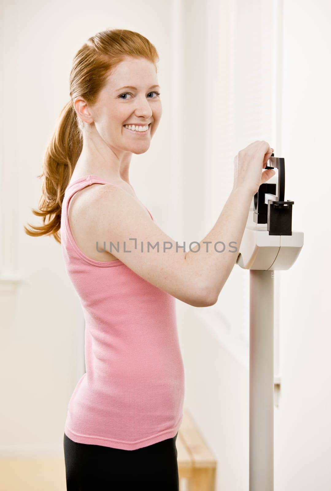 Young woman on scales after exercising. Horizontally framed shot.