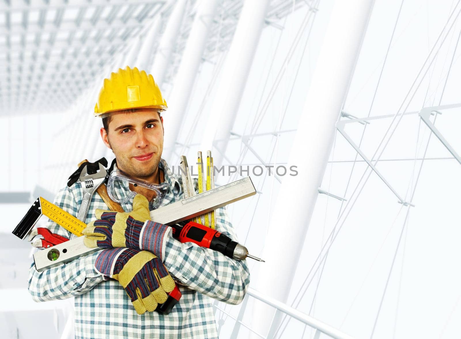 young handyman holding lots of tool, modern building background
