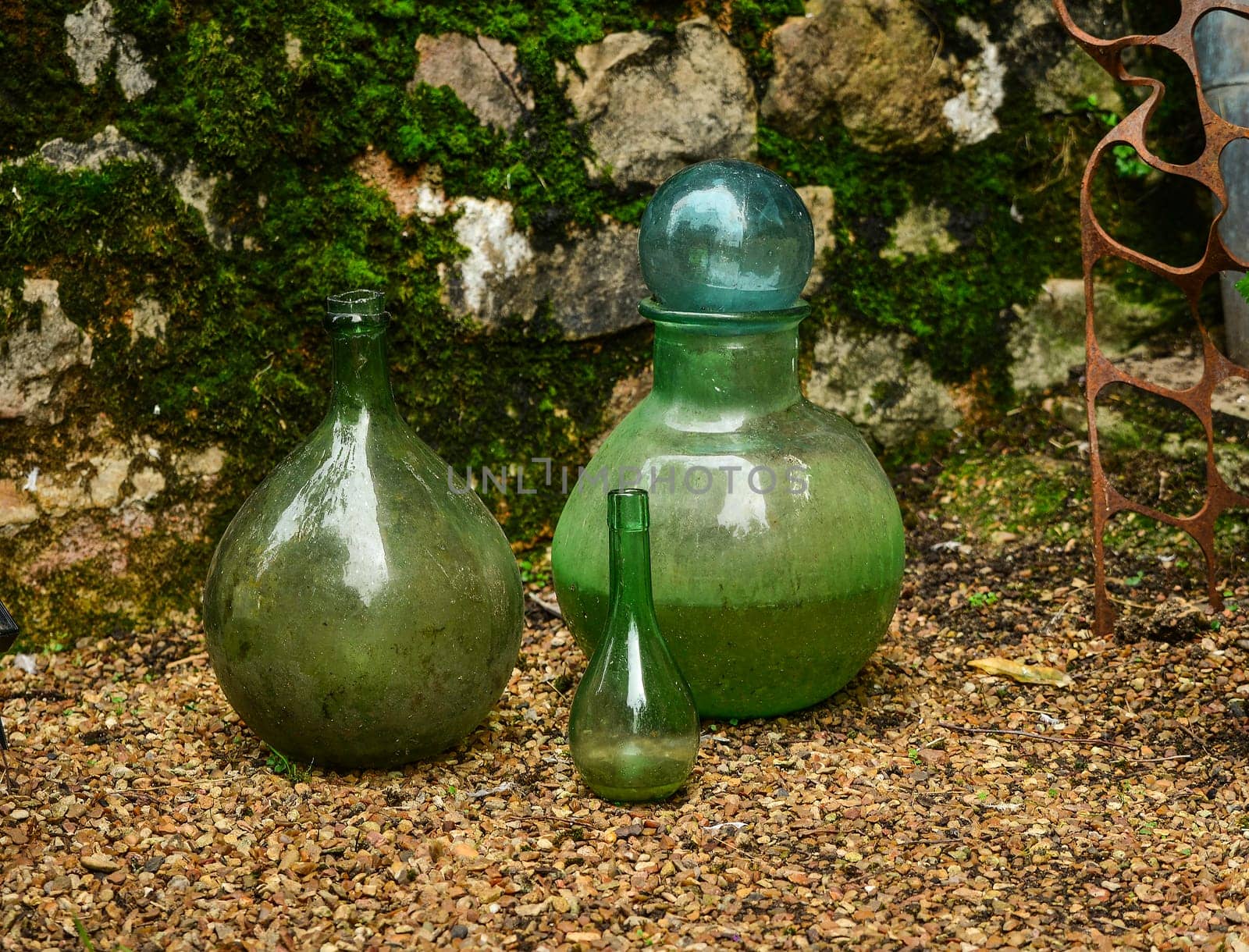 Green glass flasks on the background of a stone wall with a mold