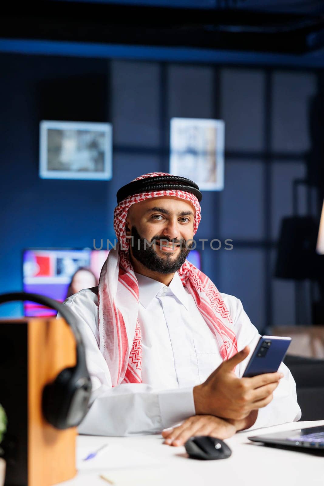 Arab man with a laptop and mobile device by DCStudio