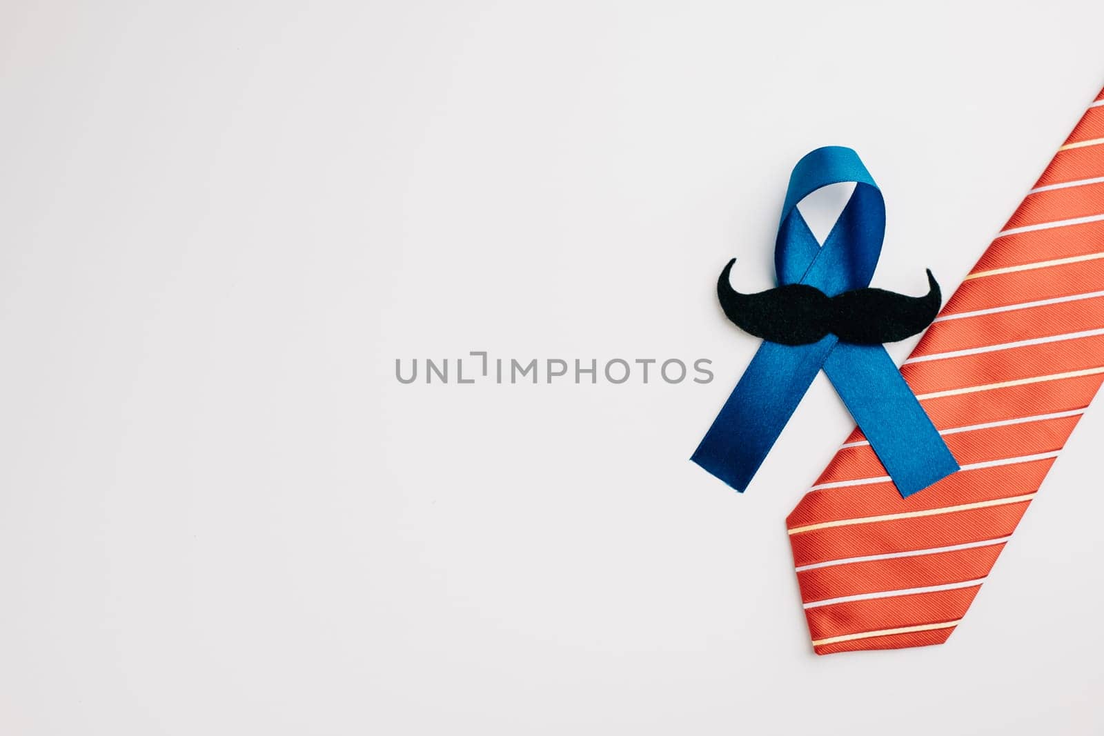 blue ribbon with a mustache and necktie is a symbol of strength and unity by Sorapop