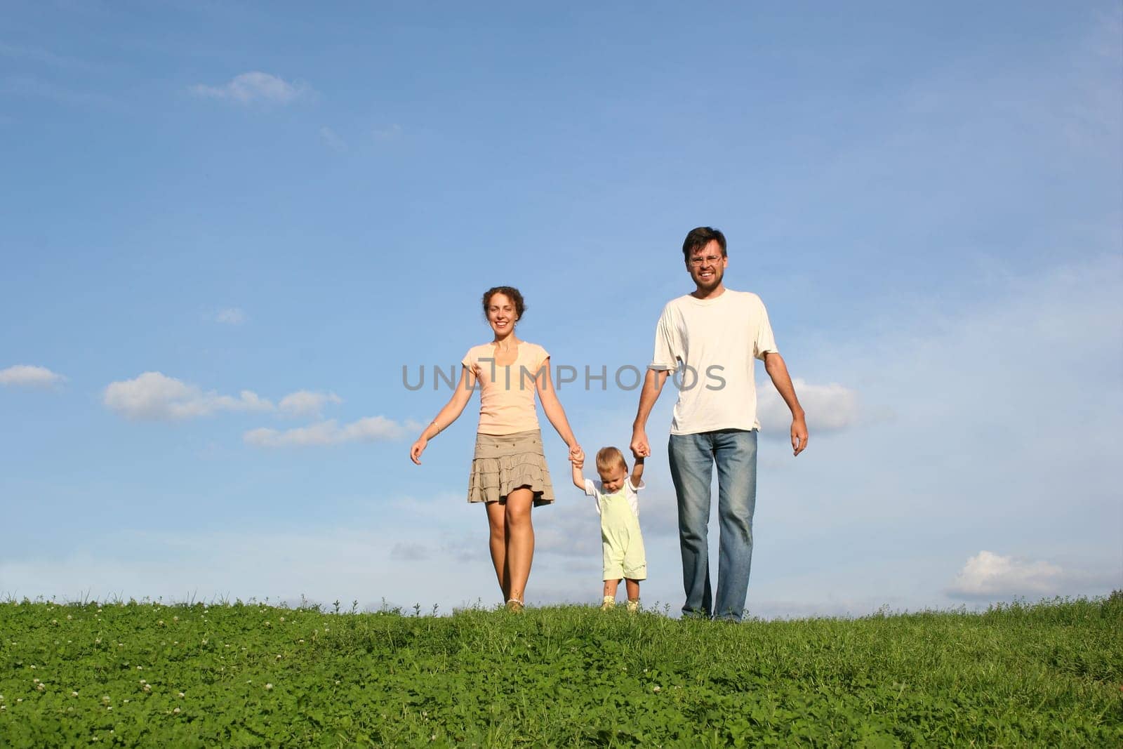 family with baby walking on grass