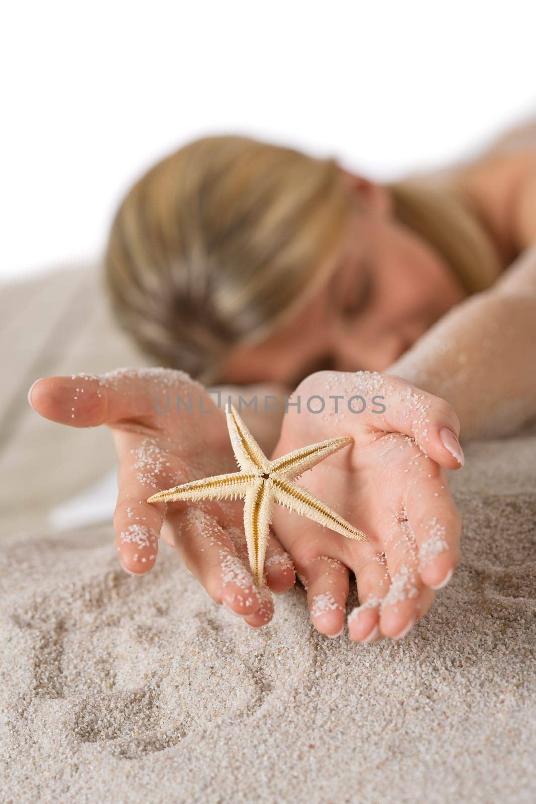 Beach - woman holding starfish lying in sand
