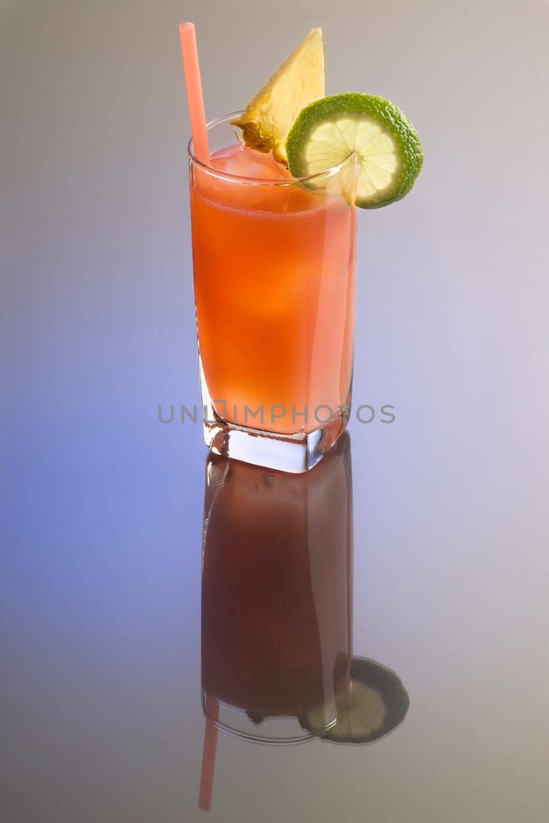 Bay Breeze mixed drink with garnish on plain background with reflection
