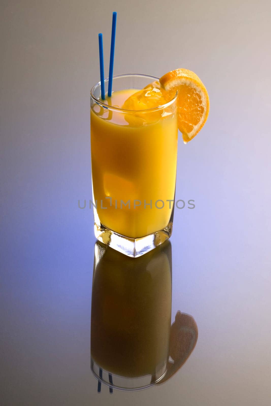 Screwdriver cocktail with orange garnish on plain background with reflection