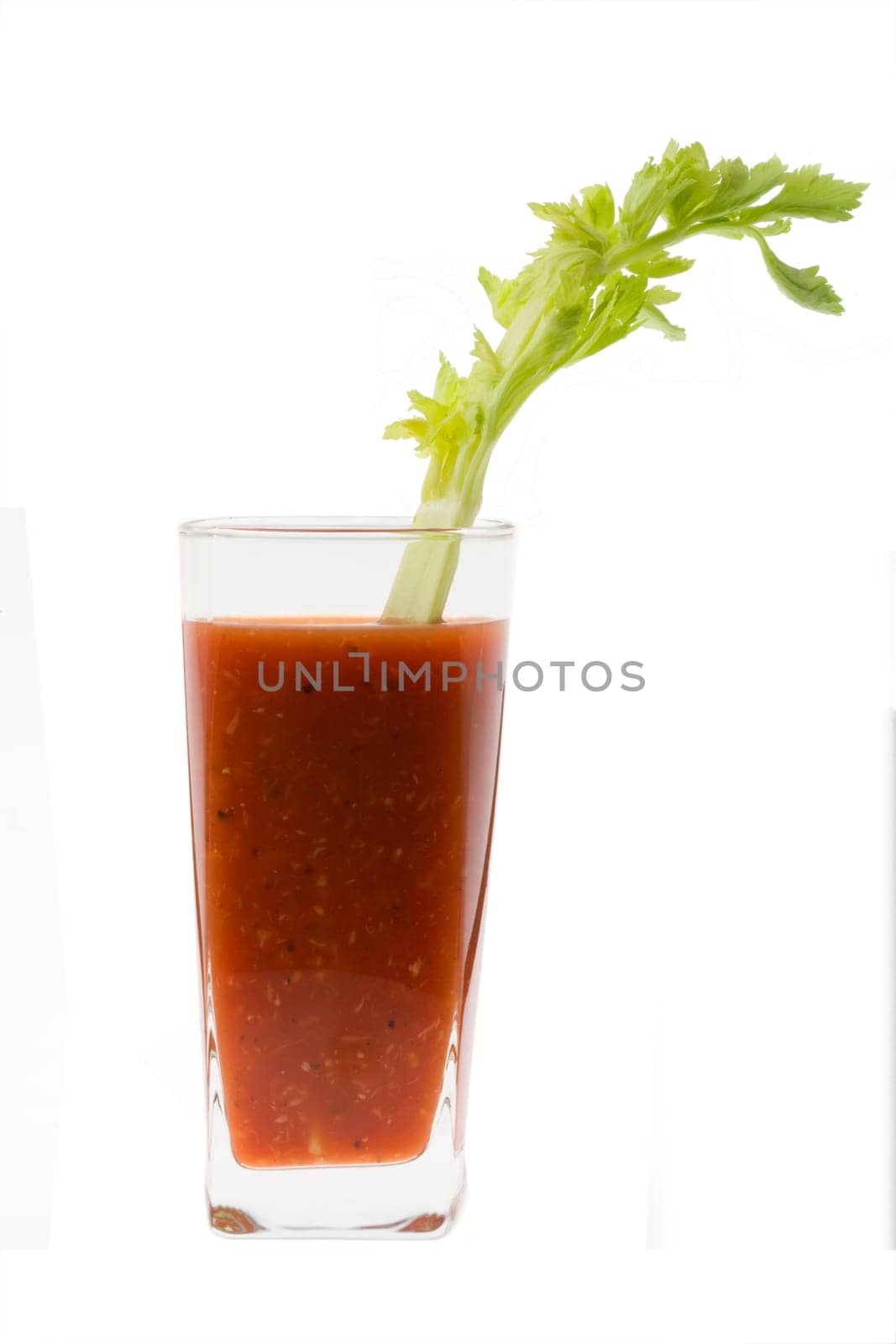 Bloody Mary mixed drink with celery garnish on white background