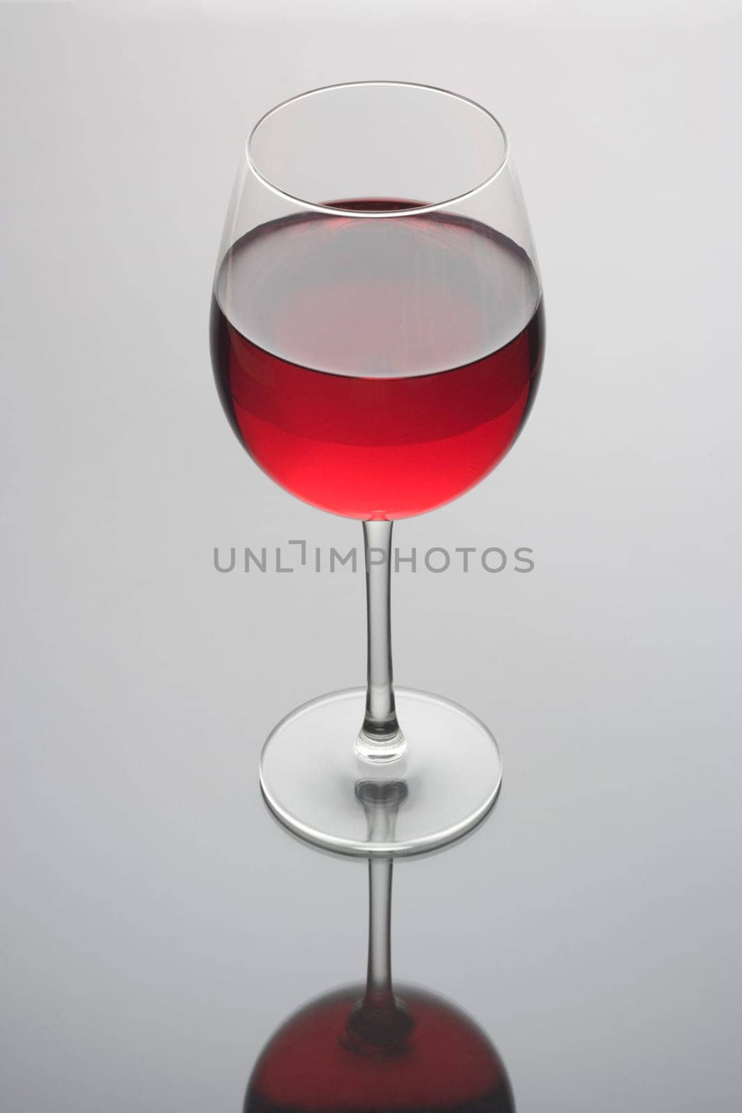 Red wine in a glass on a plain grey background