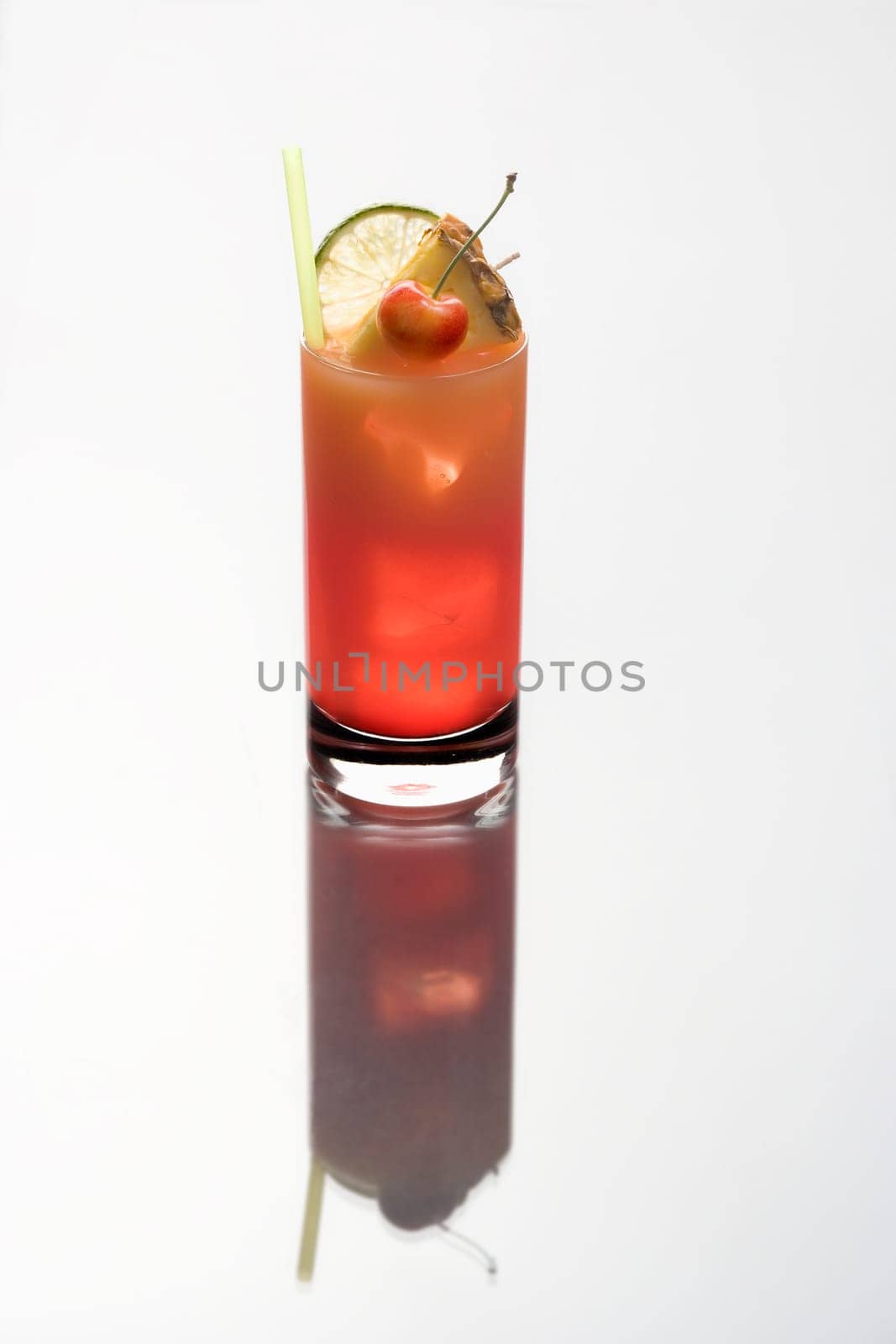 Mai Tai mixed drink with fruit garnish on a plain white background with reflection