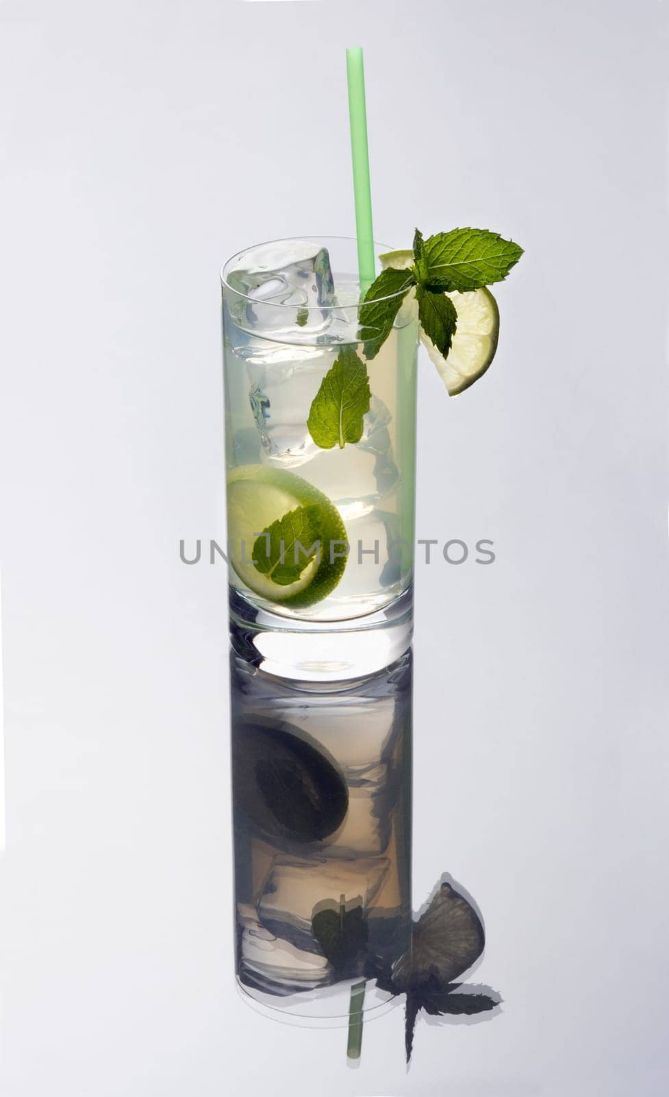 mojito mixed drink on a plain grey background with reflection