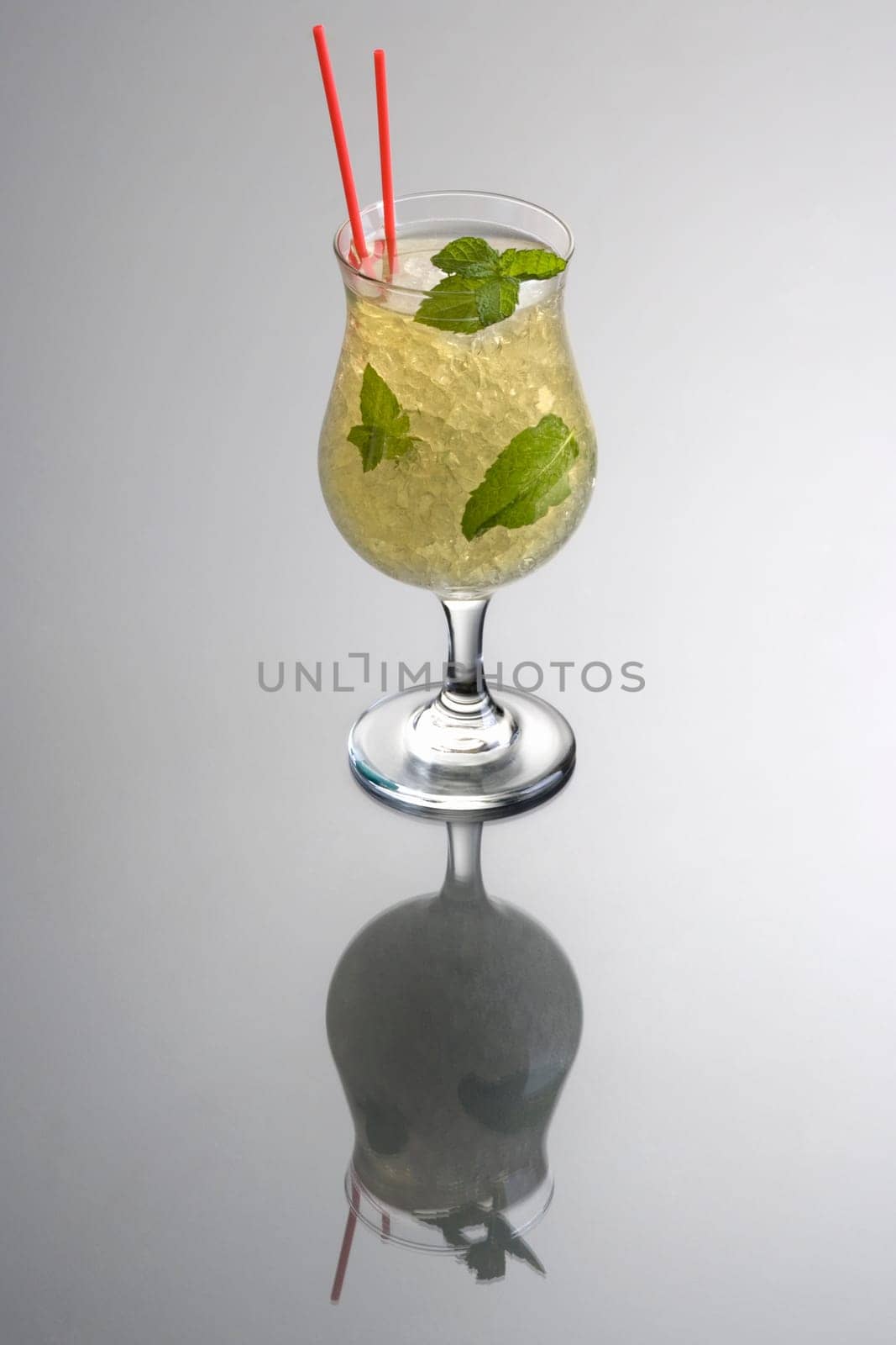 Mint Julep mixed drink on grey background with reflection