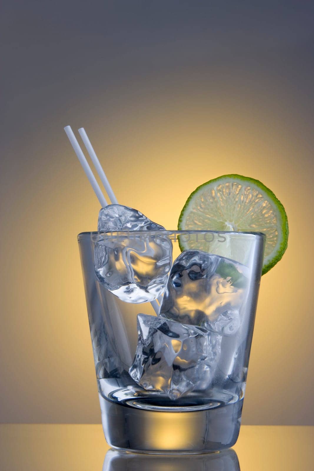 Club Soda on the rocks with lime slice garnish on plain background