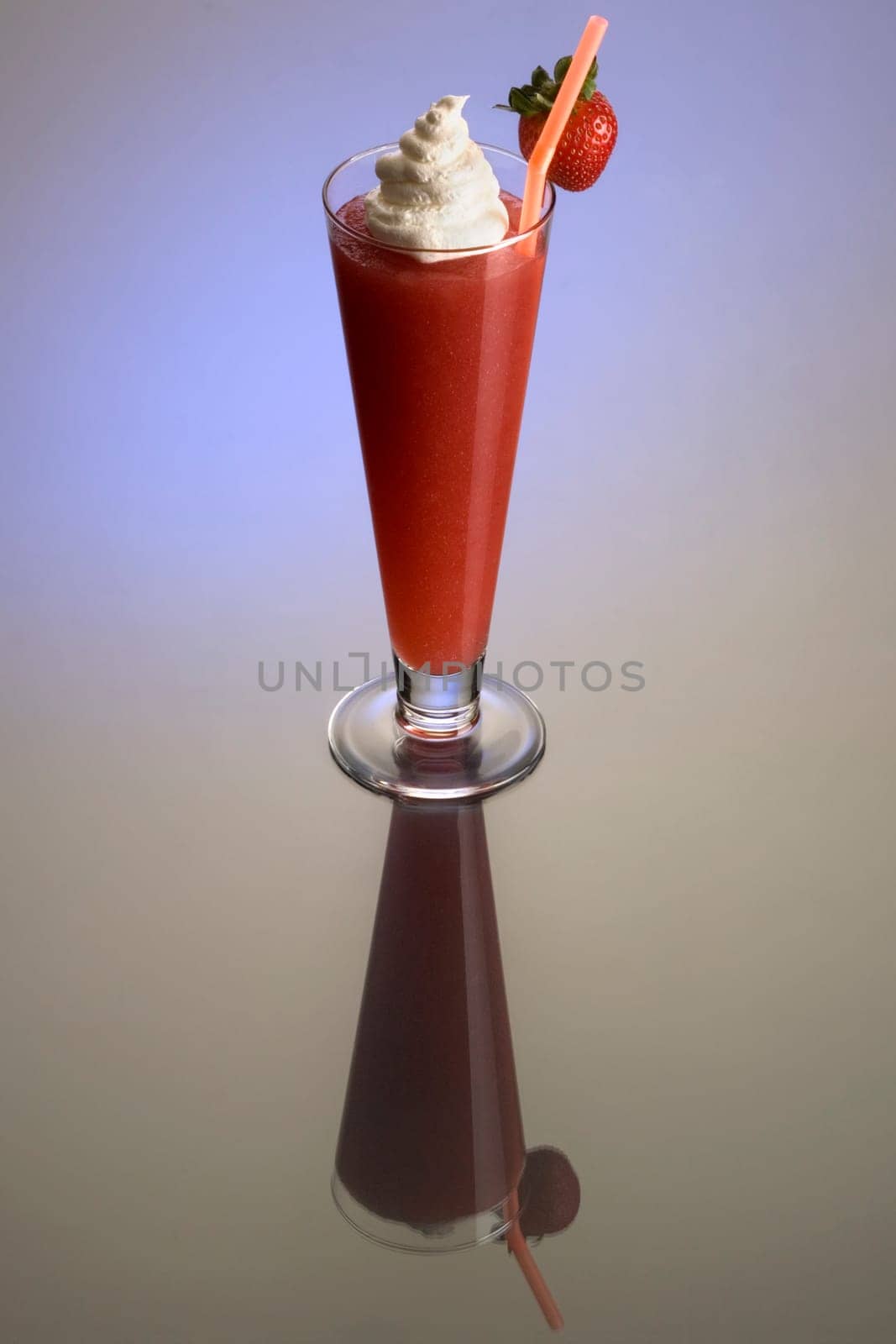Frozen strawberry Daiguiri mixed drink with whipped cream and fruit garnish on plain background with eflection