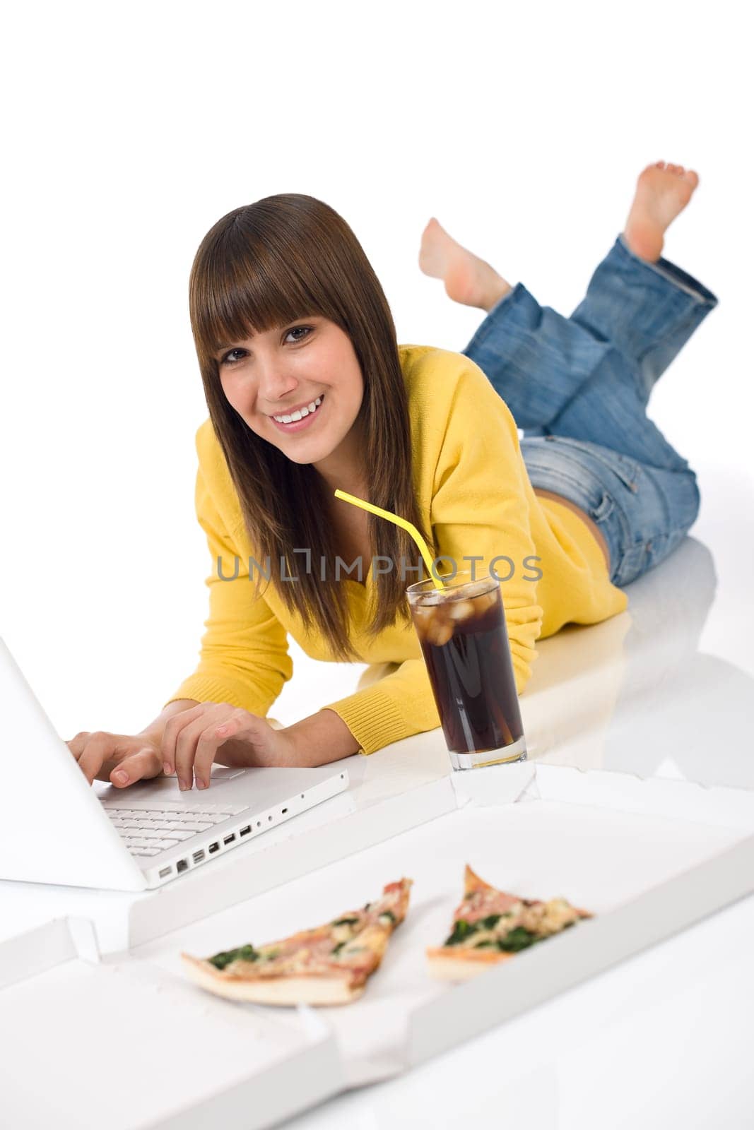 Happy female teenager with laptop lying down