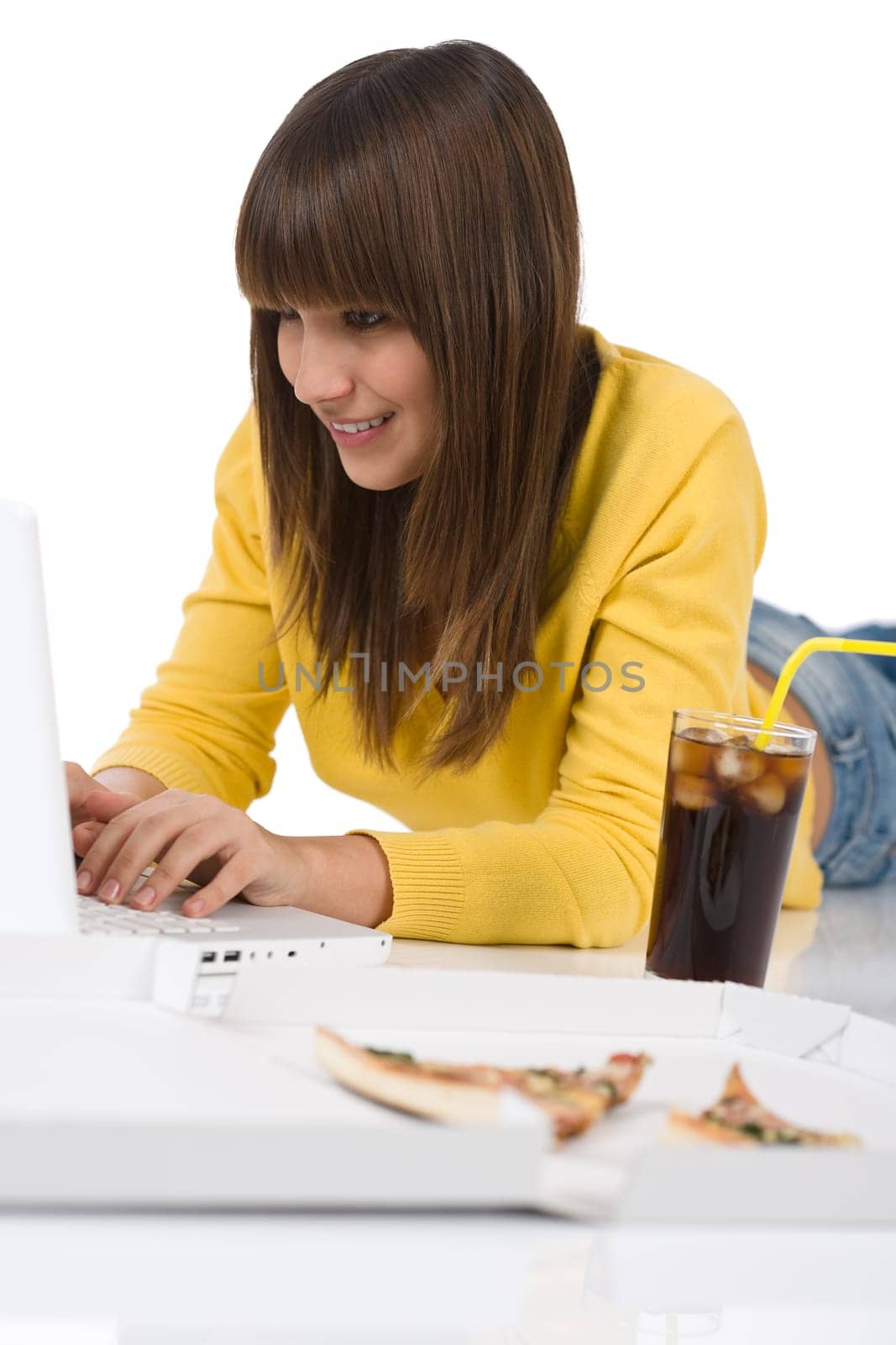 Happy female teenager with laptop lying down