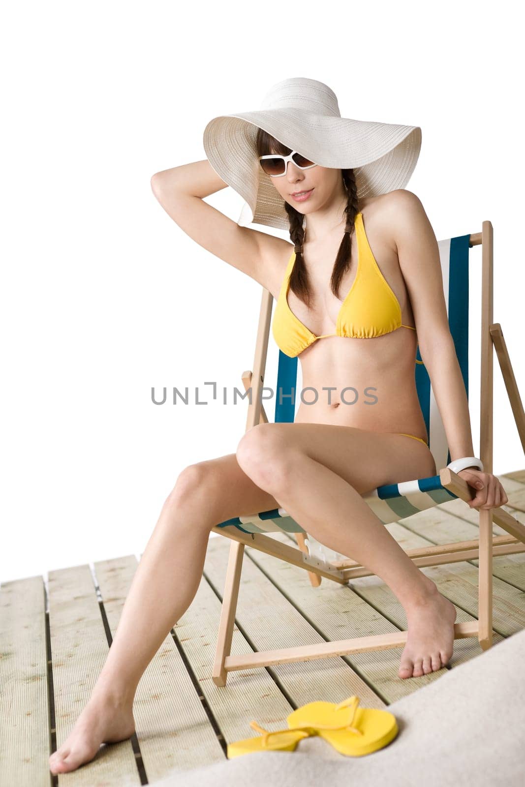 Beach - woman with hat in yellow bikini sunbath