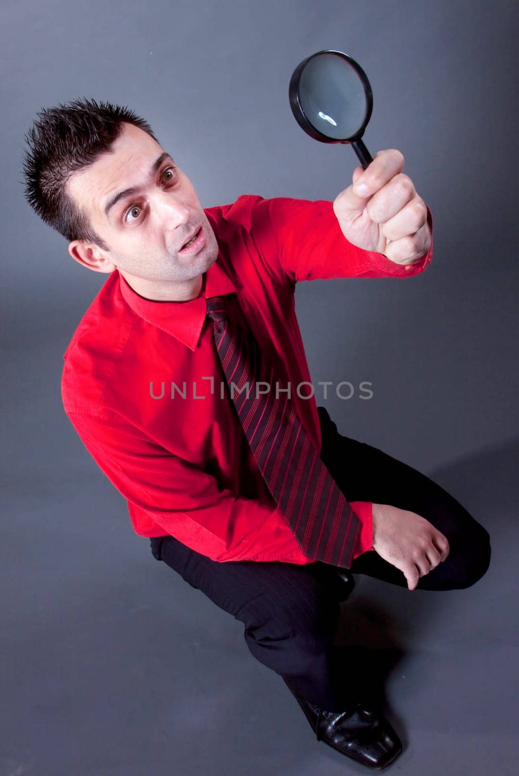 Funny businessman with magnifying glass