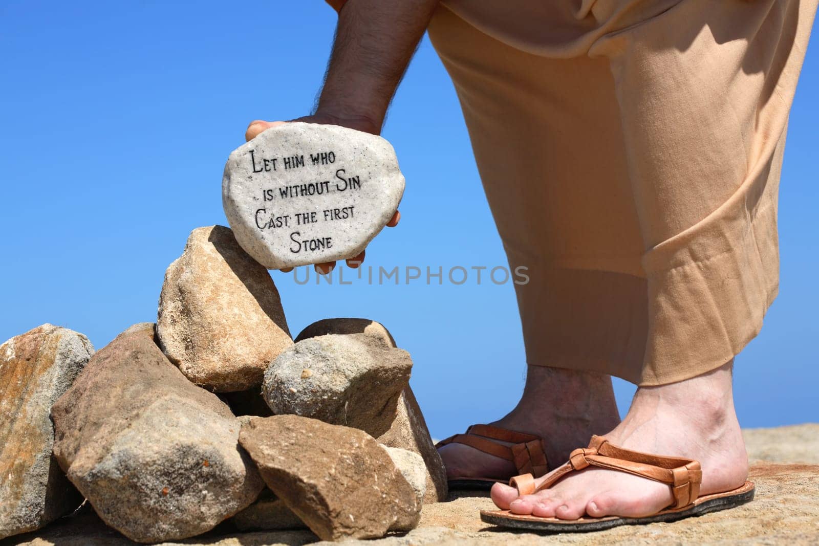 Man holding rock with religious verse