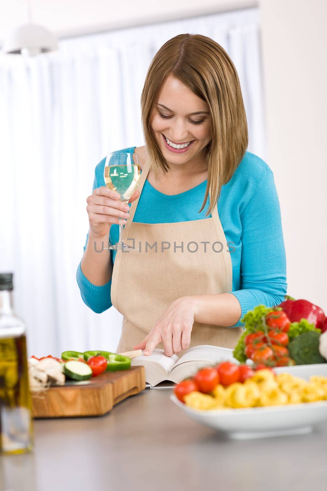 Cooking - Smiling woman reading recipe from cookbook