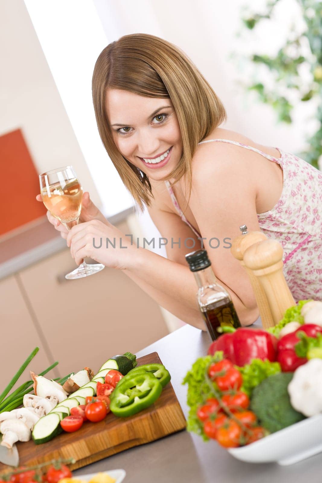 Cooking - smiling woman with glass of white wine and vegetable