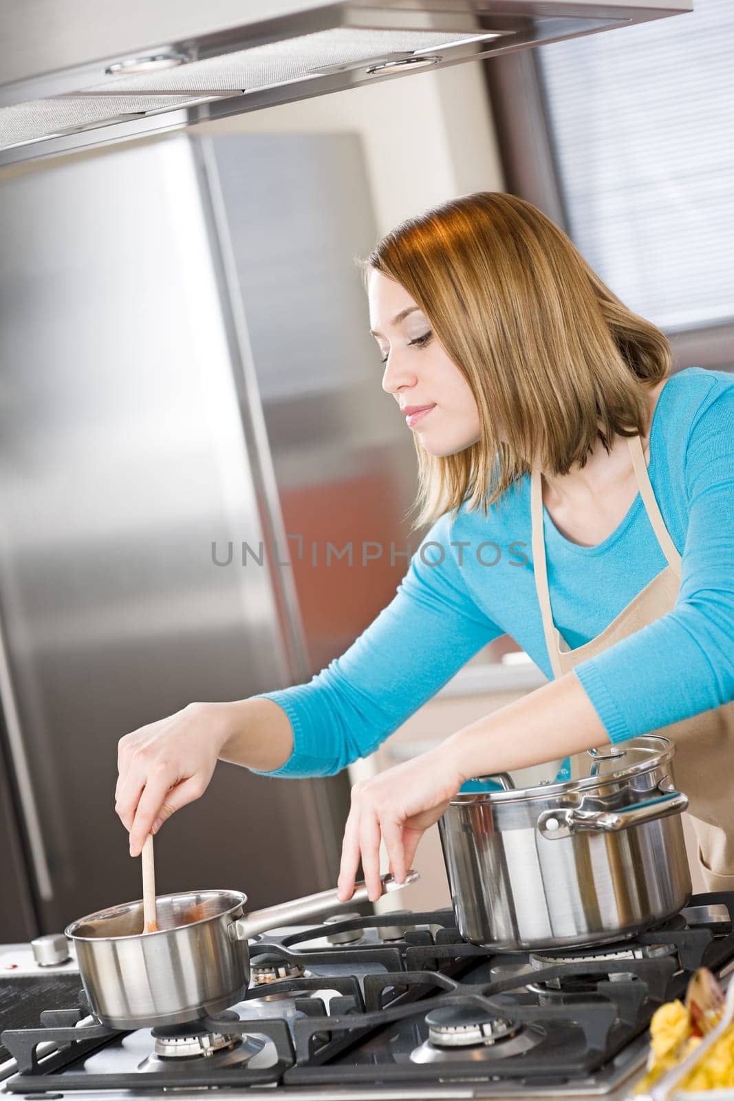 Cooking - Woman stir Italian tomato sauce in modern kitchen