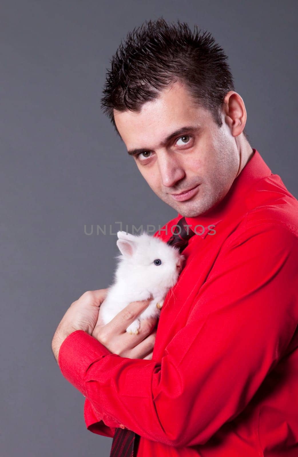 Handsome young man holding baby rabbit
