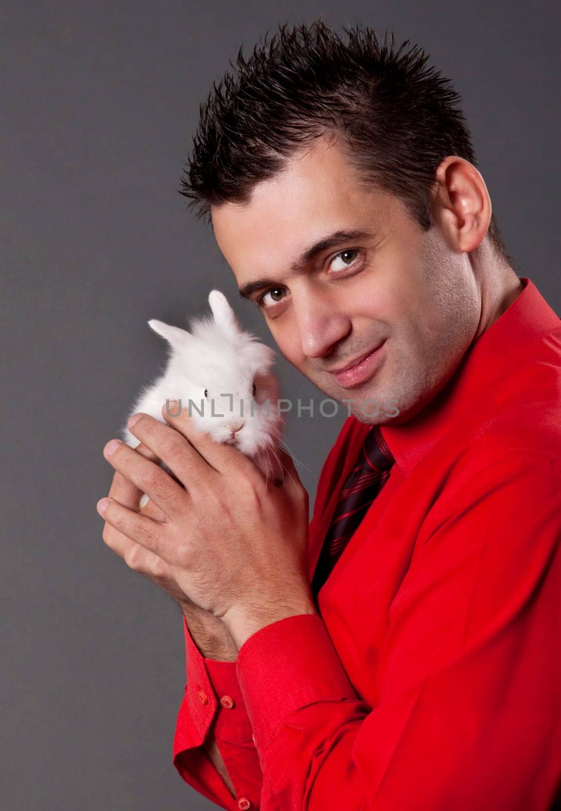 Handsome young man holding baby rabbit