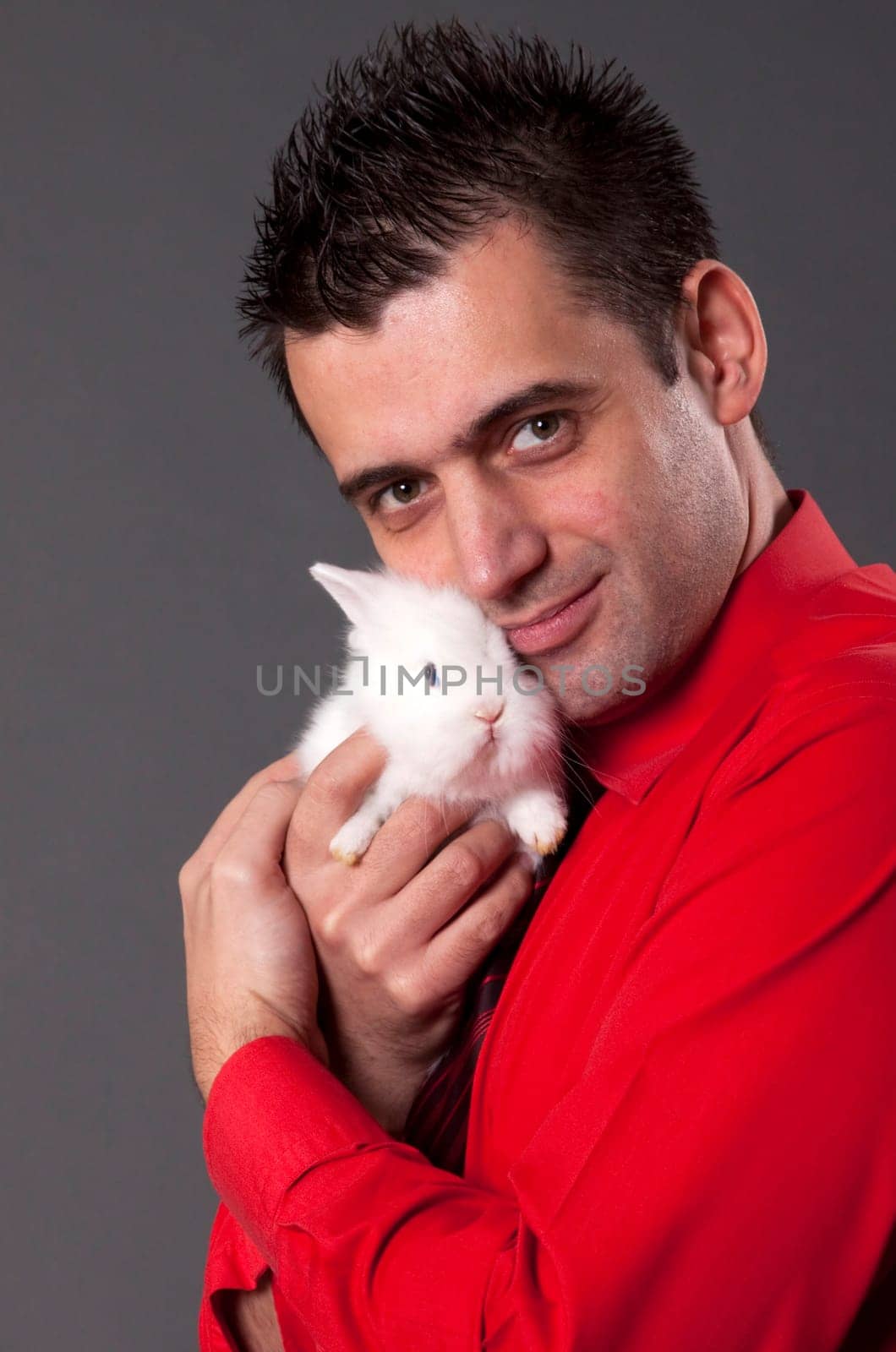 Handsome young man holding baby rabbit