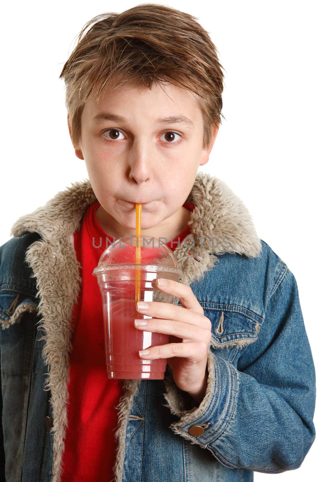 Child drinking fresh fruit juice through a straw