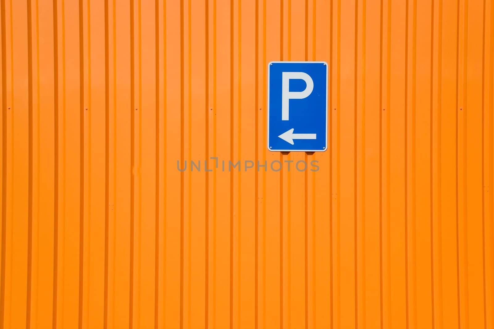 Blue sign on orange steel wall