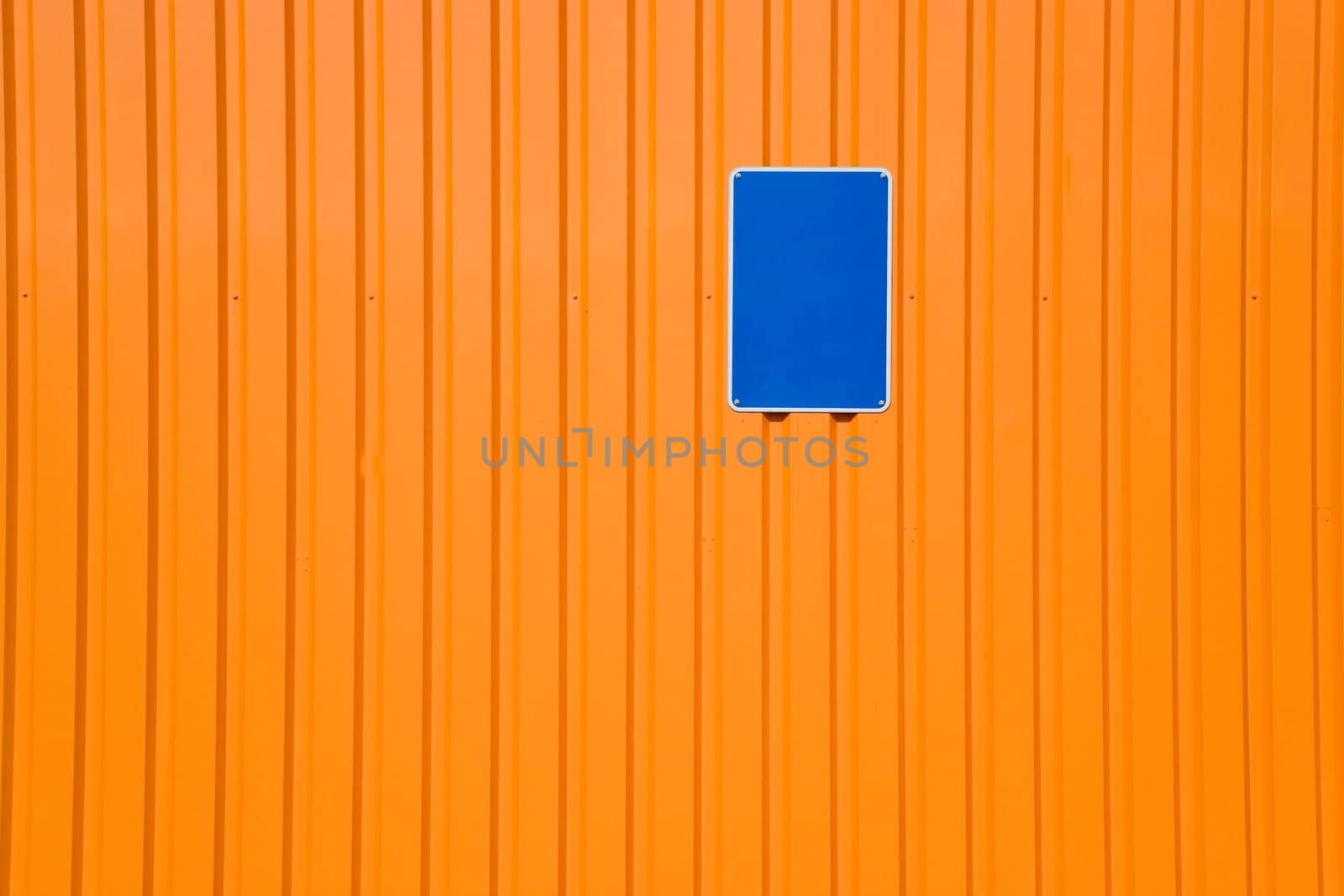 Blue sign on orange steel wall