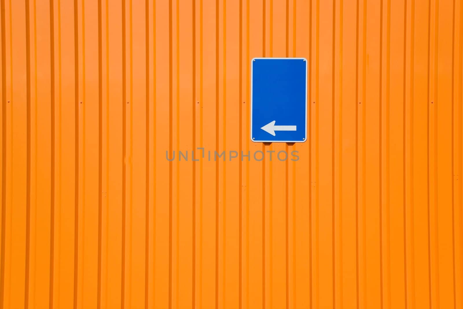 Blue sign on orange steel wall