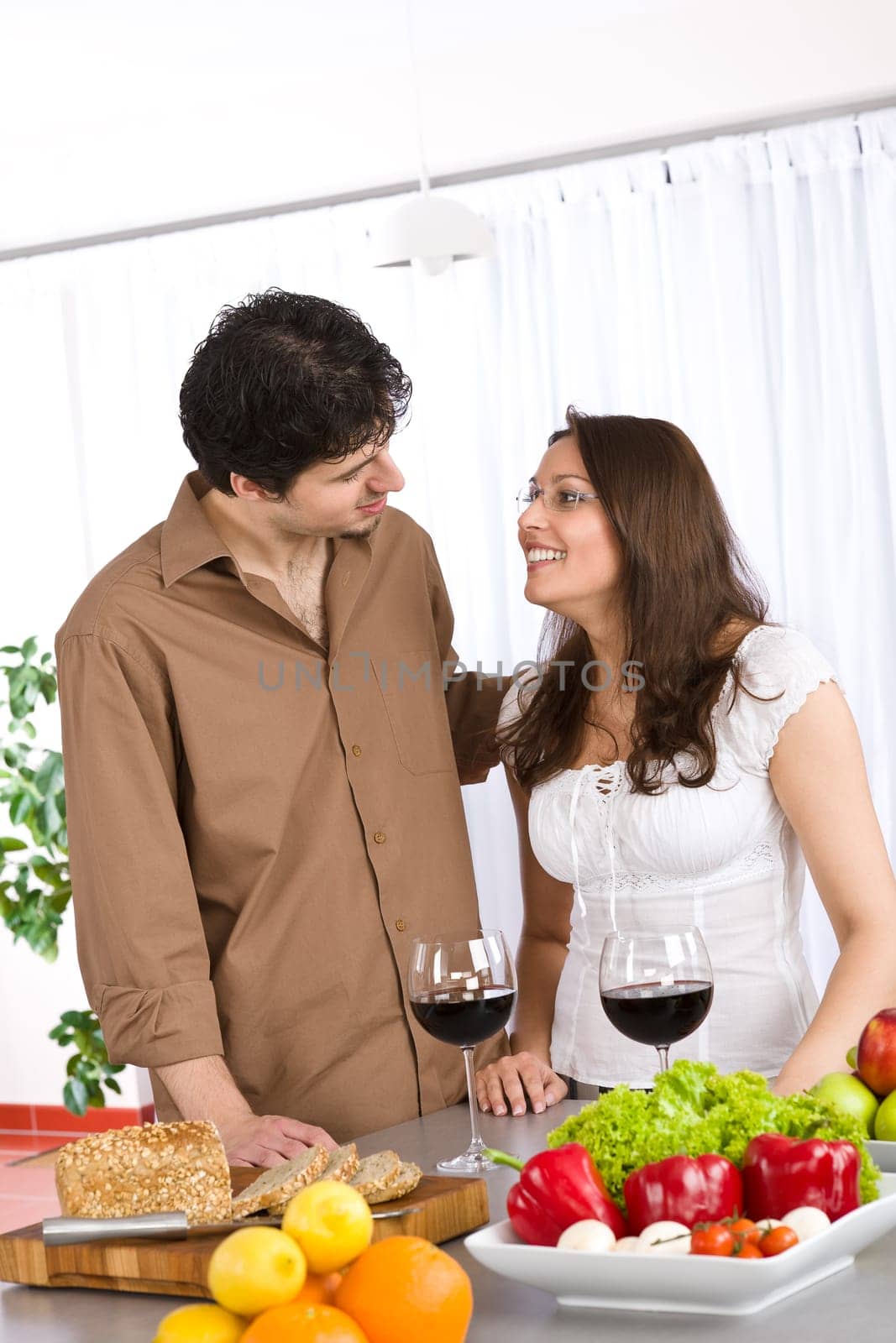 Happy couple in modern kitchen with red wine