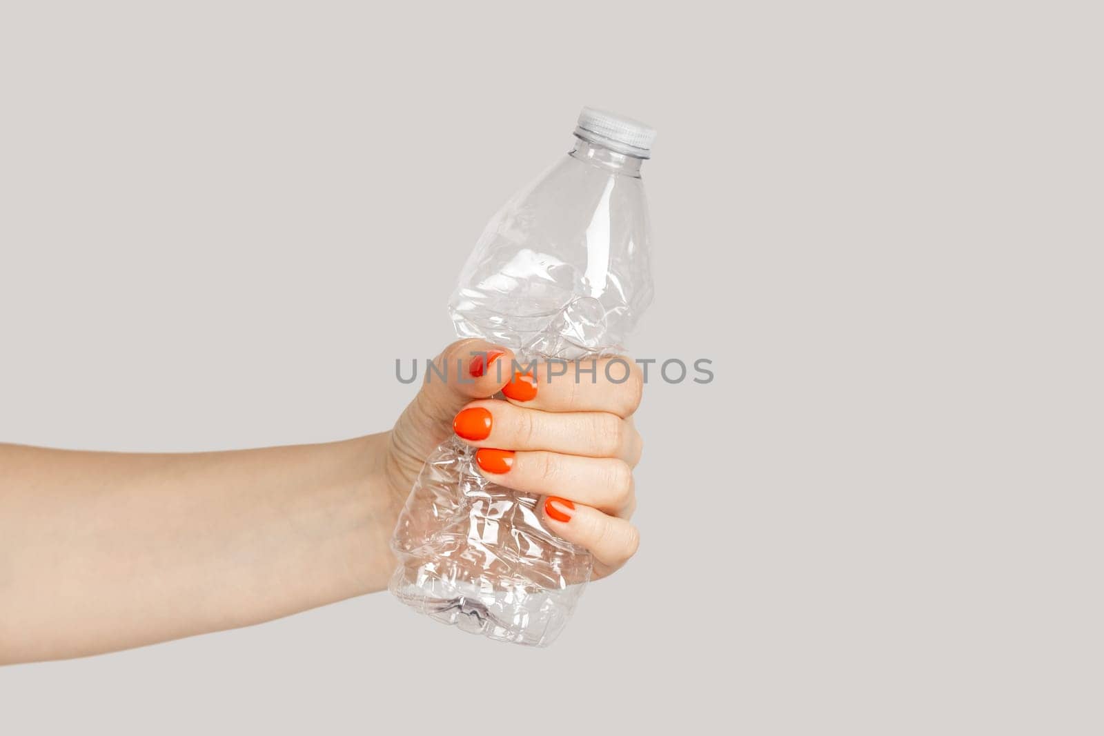 Woman hand crumpling plastic bottle, sorting rubbish, eco, saving environment. by Khosro1