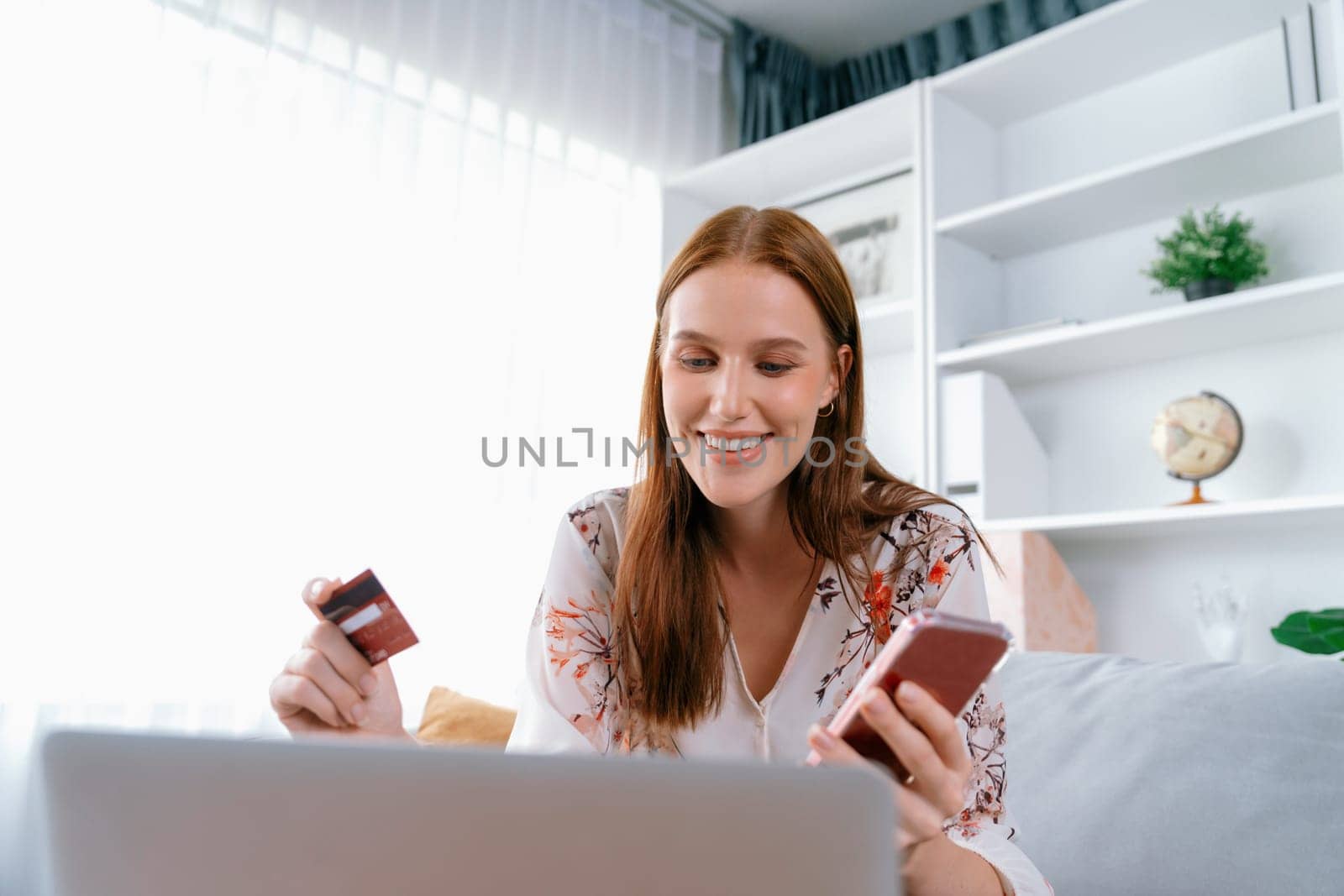 Young happy woman buy product by online shopping at home while ordering items from the internet with credit card online payment system protected by utmost cyber security from online store platform