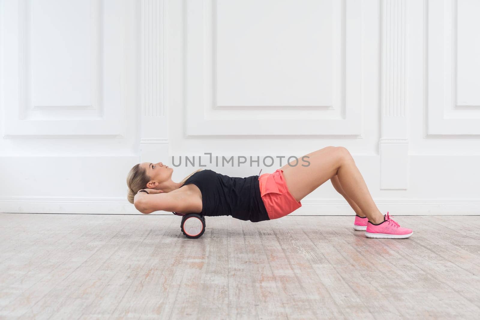 Slim woman using foam roller in gym to workout to remove the pain, stretching and massaging muscles. by Khosro1