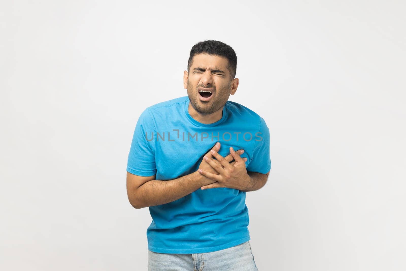 Stressed sick unshaven man standing with hands on chest, having heart attack, screaming from pain. by Khosro1