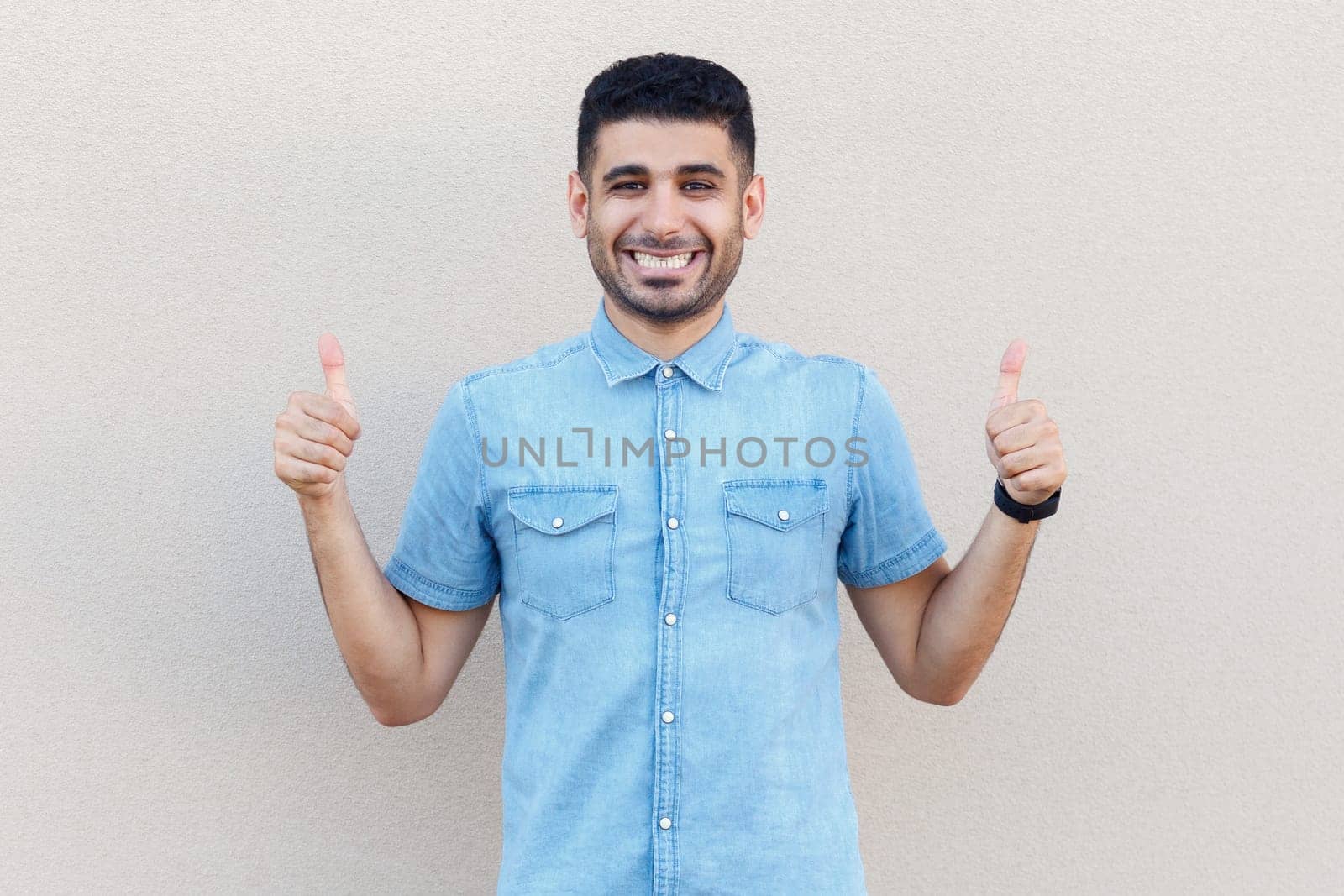 Extremely happy joyful cheerful man looking at camera with toothy smile, showing thumbs up, approved by Khosro1