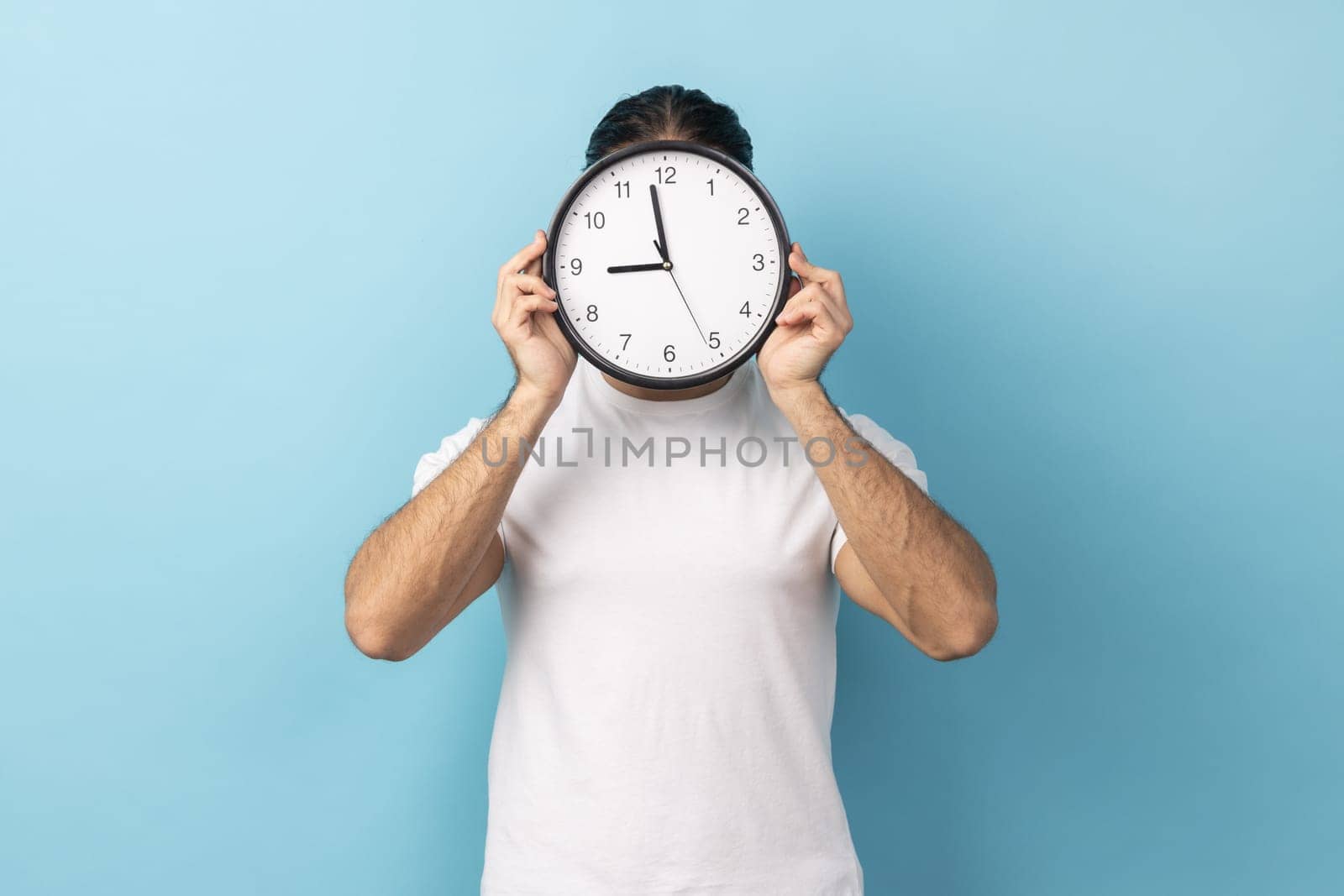 Man holding wall clock hiding her face, time management, schedule and meeting appointment. by Khosro1