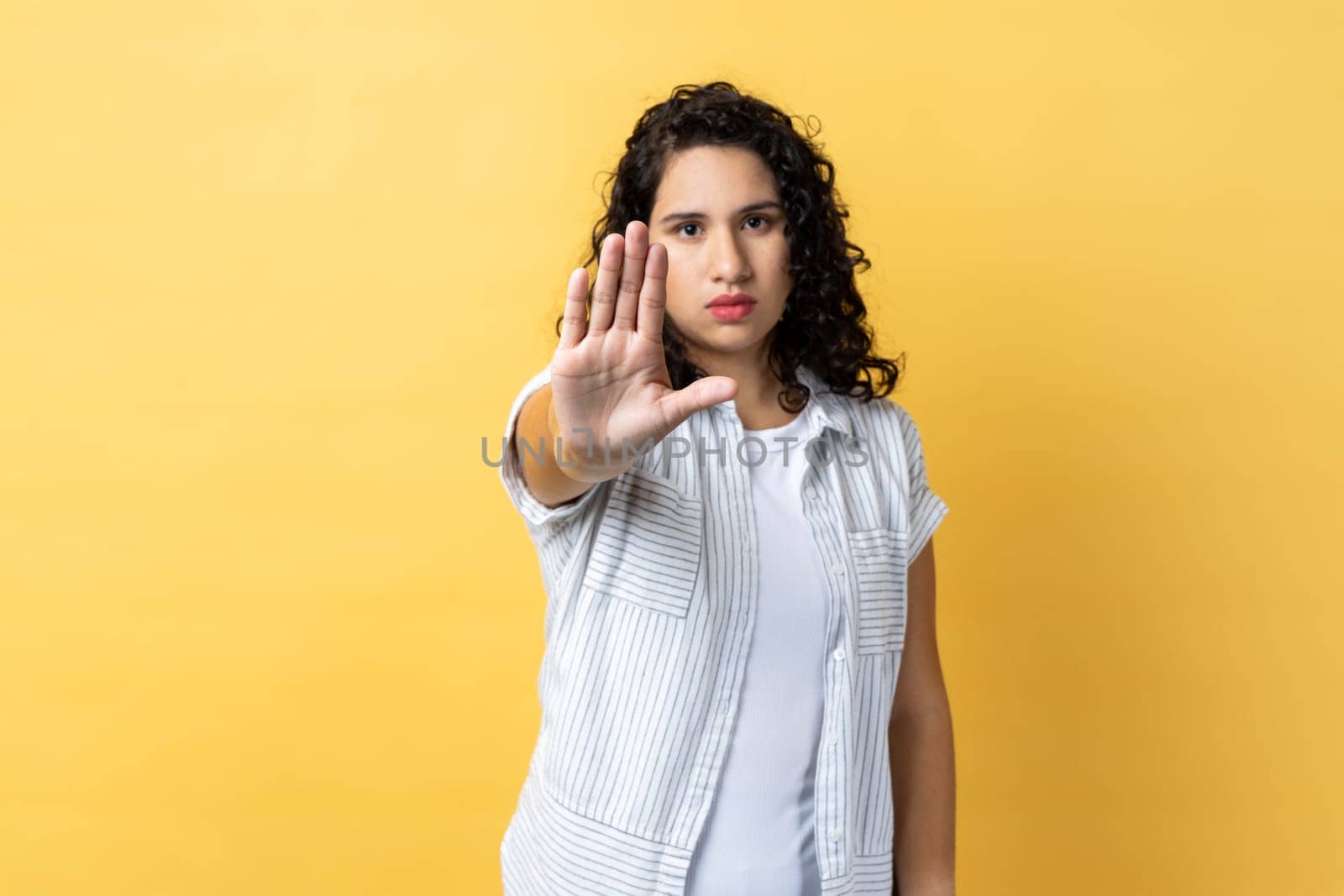 Woman showing stop gesture with palm of hand, trying to stop abuser, rejection, domestic violence. by Khosro1