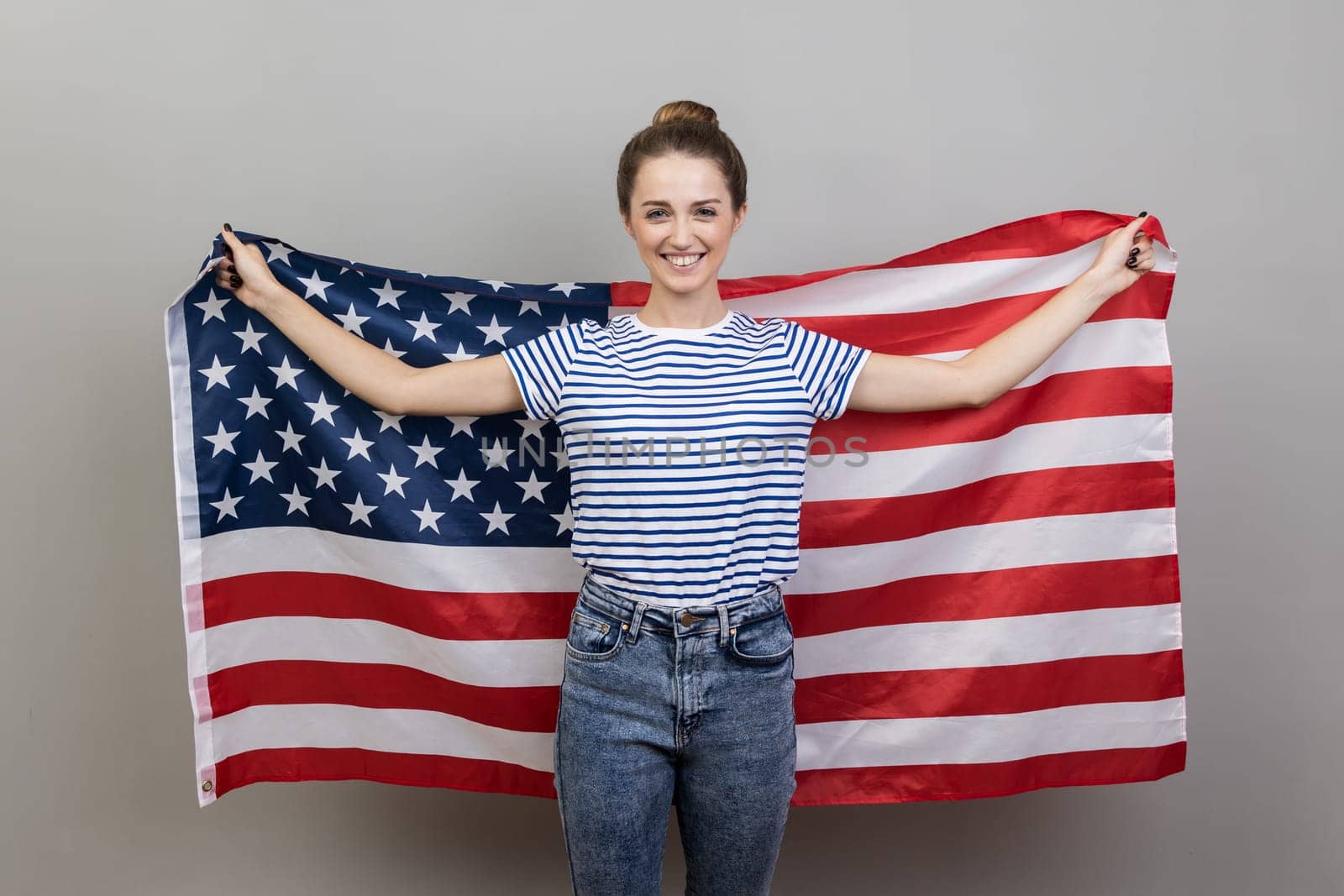 Woman holding big american flag, expressing positive emotions and happiness. by Khosro1