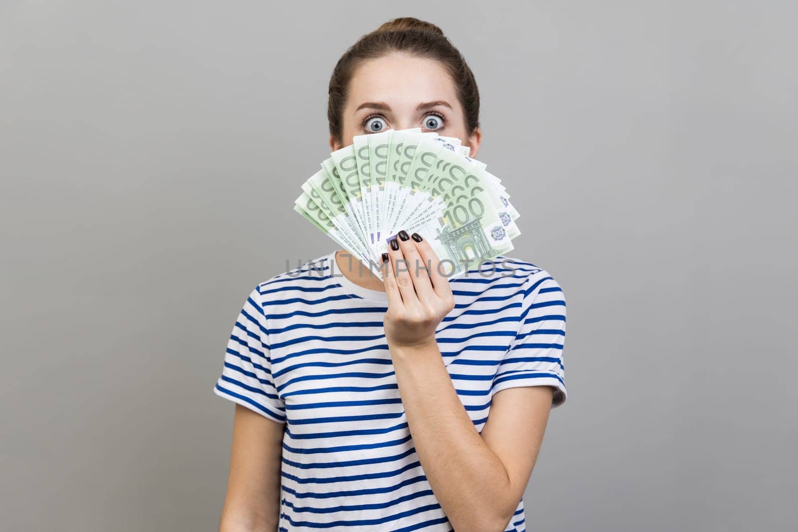 Woman peeping out euro banknotes with playful look, enjoying big jackpot, financial success. by Khosro1